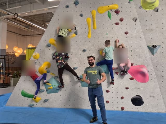 Grupa dzieci na ścianie boulderowej podczas zajęć wspinaczkowych w Warszawie